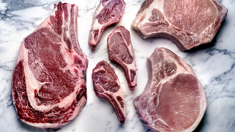 Raw steaks on marble background