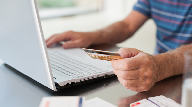 Hand with laptop and credit card