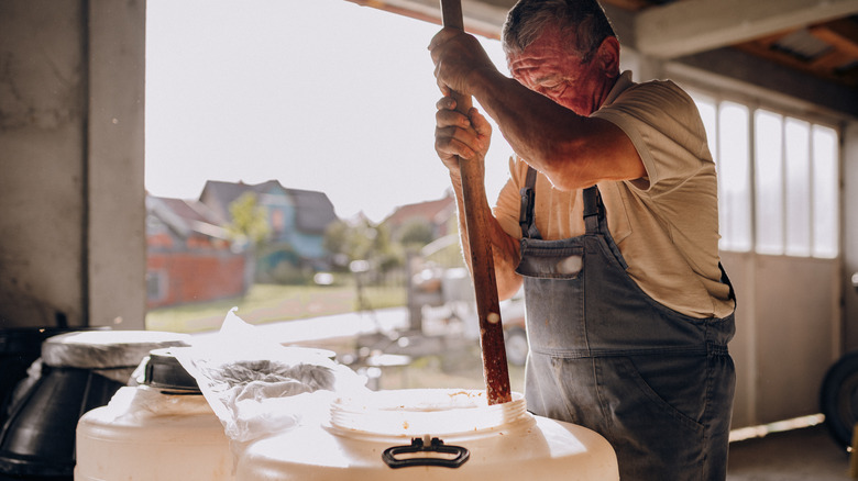 Distiller preparing mash for moonshine