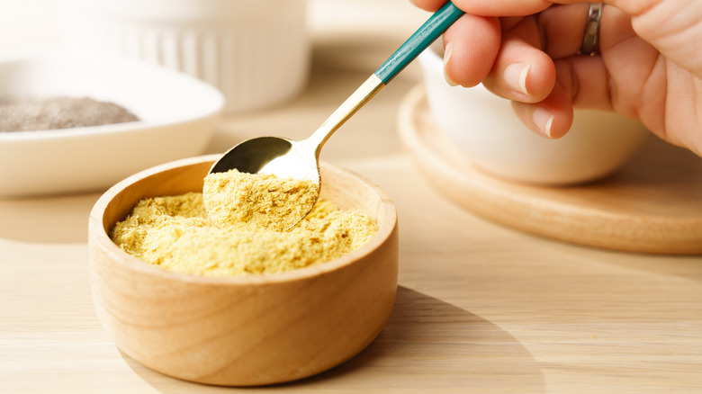 scooping nutritional yeast flakes