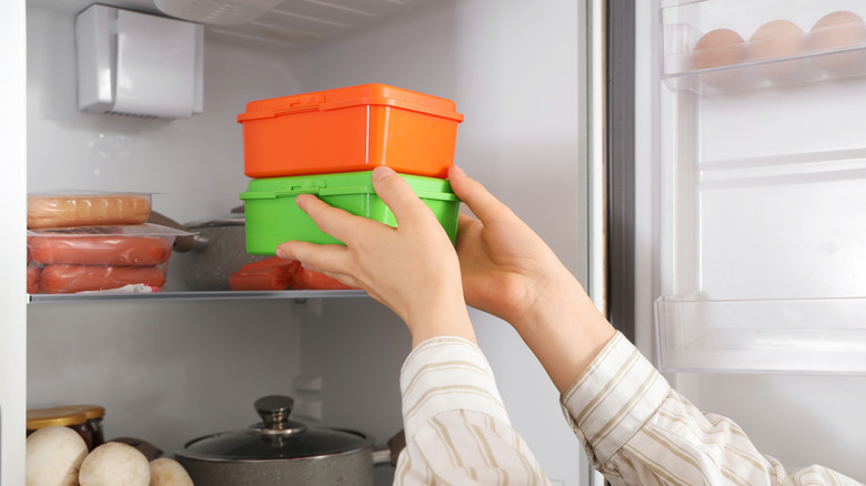 woman putting containers in fridge