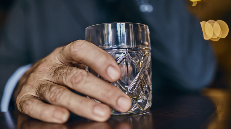 man holding bourbon glass