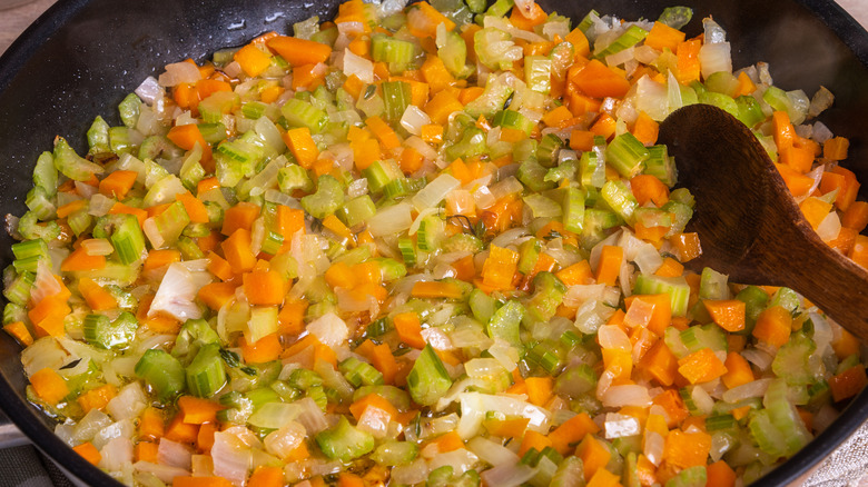 pan filled with softened soffritto and wooden spoon