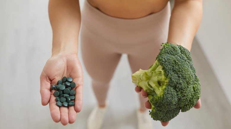 woman holding spirulina and broccoli