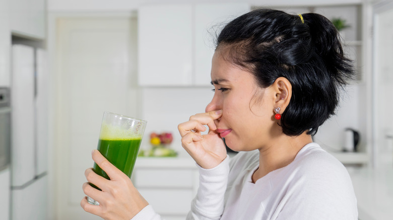 woman reluctantly holding juice