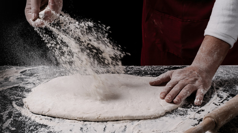 hands preparing pizza dough