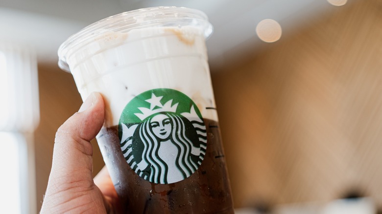 Hand holding a Starbucks espresso with cold foam