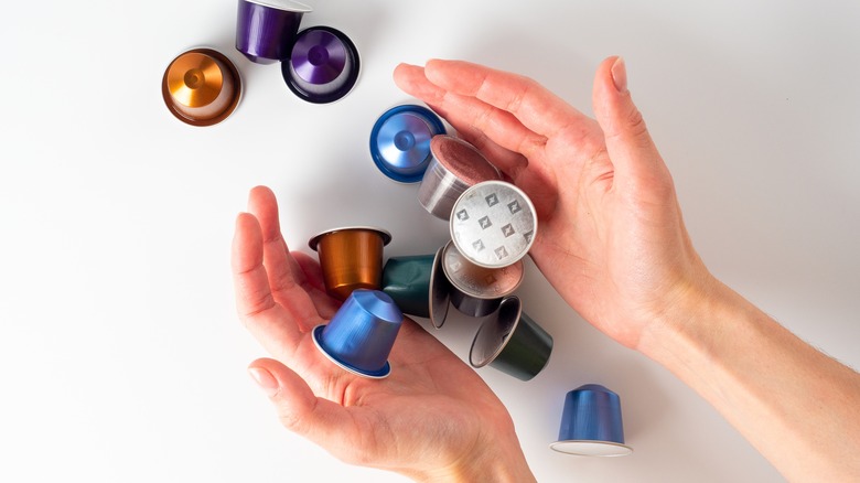 hands holding Nespresso coffee pods