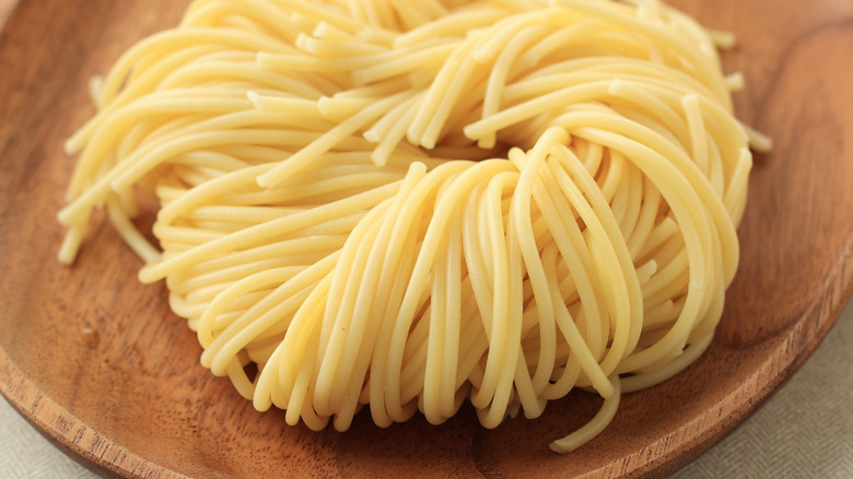 nest of angel hair pasta on wooden dish