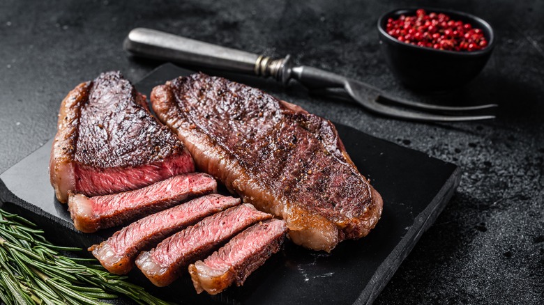 Two top sirloin steaks with herbs and seasoning.