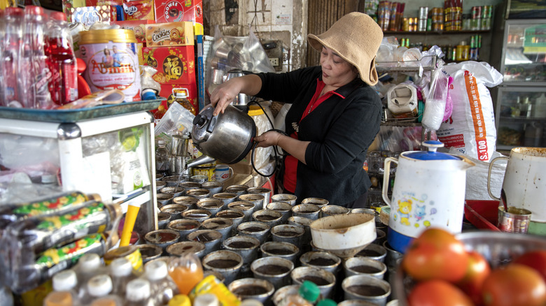 woman pouring drinks in Vietnamese cafe