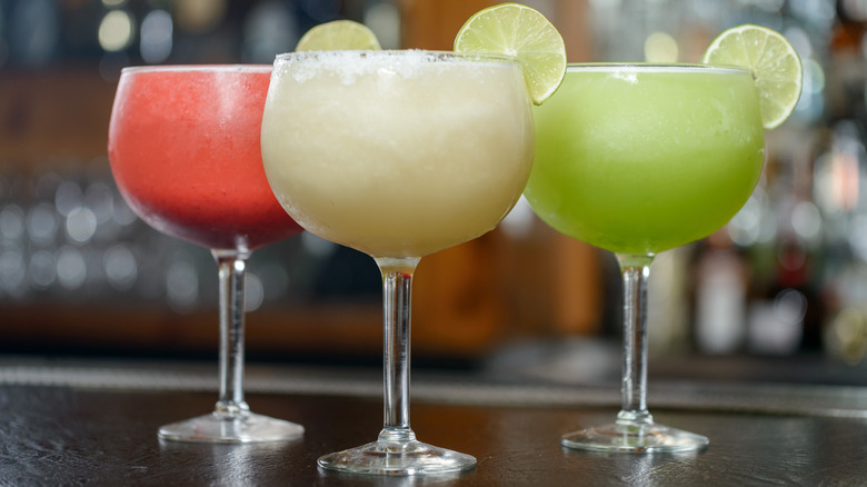 three different frozen margaritas on a table