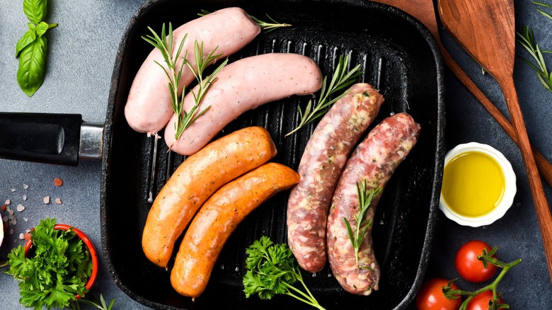 Overview of different colored sausages in a pan