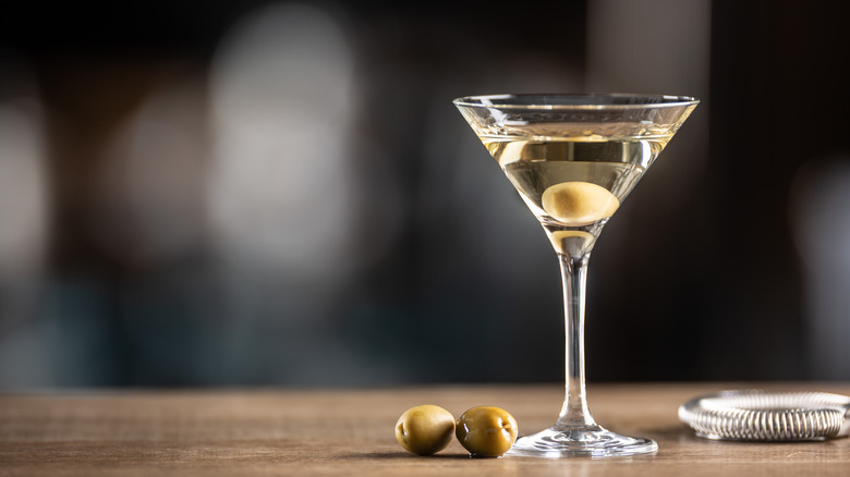 martini on bar with olive garnish