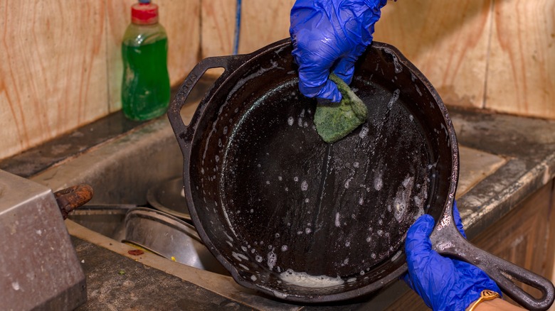 Woman's hands cleaning cast iron pan