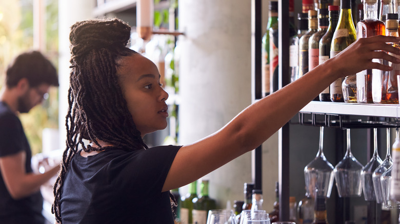 Bartenders organizing shelves