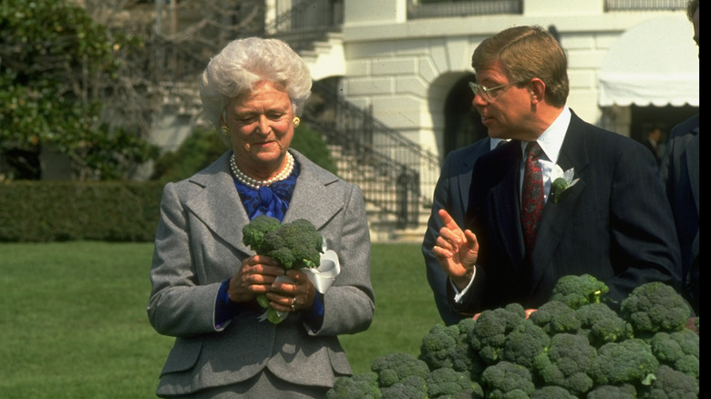 First lady Barbara Bush is presented with 10-tons of broccoli from United Fresh Fruit and Vegetable Association President George Dunlop after George H. W. Bush enacted a broccoli ban