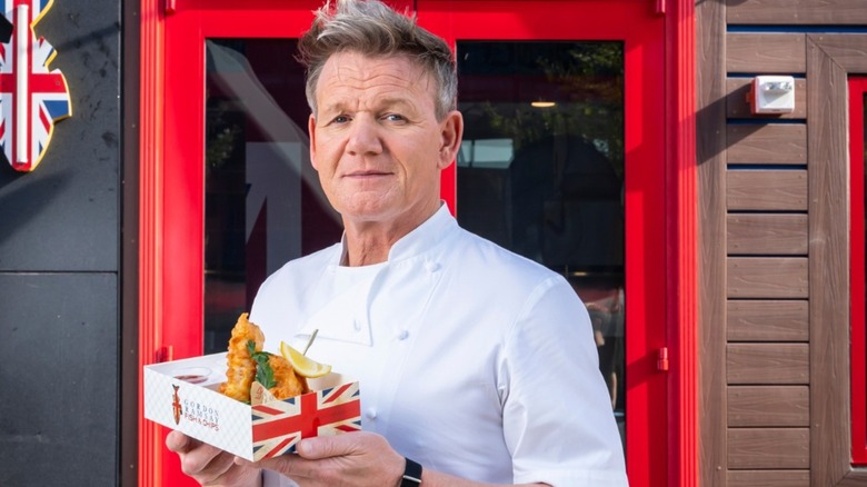 Gordon Ramsay holding a basket of fish and chips