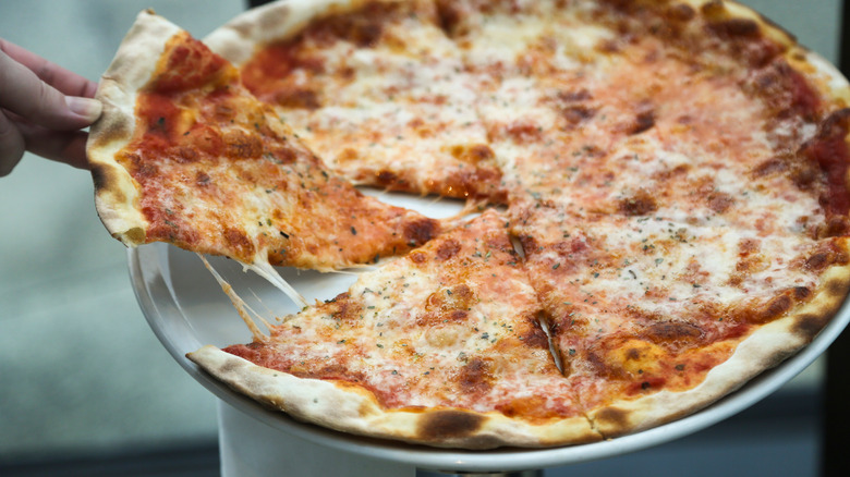 Hand holding a slice of pizza