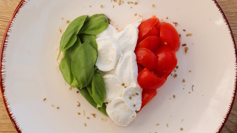 Basil, mozzarella, and tomatoes shaped into a heart