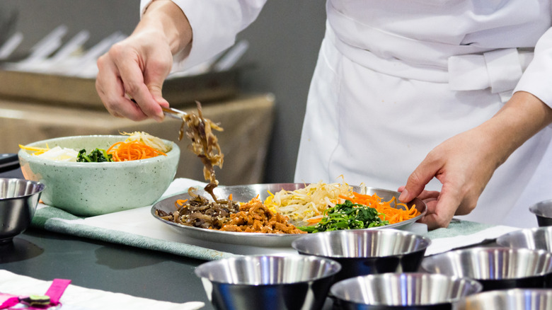 Chef preparing bowl of bibimbap