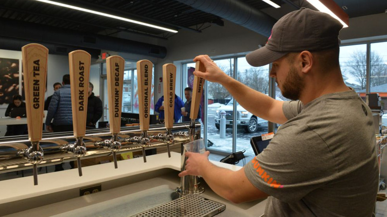 Barista pouring Dunkin' on tap