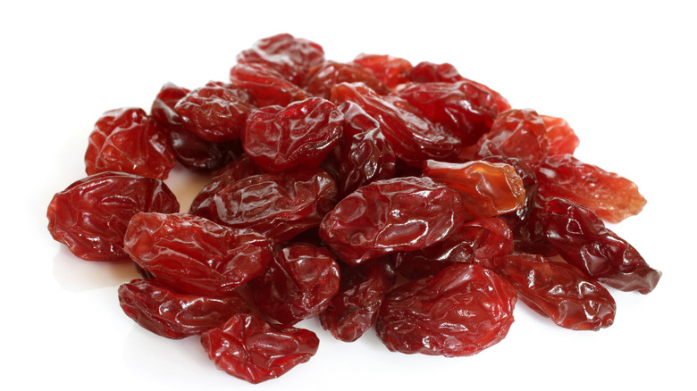 Red raisins on white background