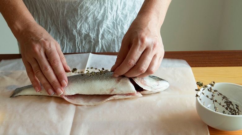 Fishmonger wrapping a fish in butcher paper