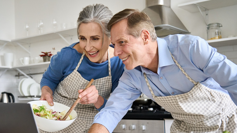 Couple looking at online recipe in kitchen