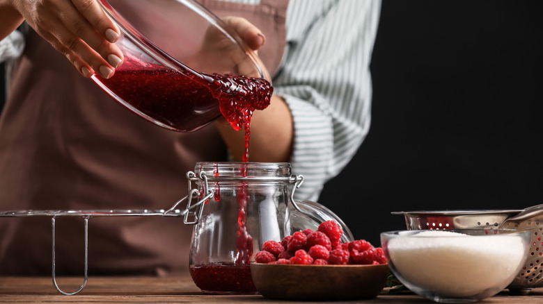 woman pouring jam into jar