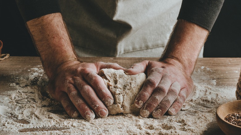 man kneading dough