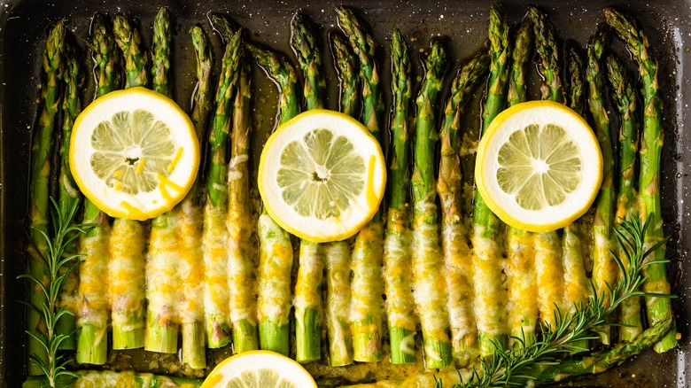 Asparagus in roasting tray with lemon and cheese