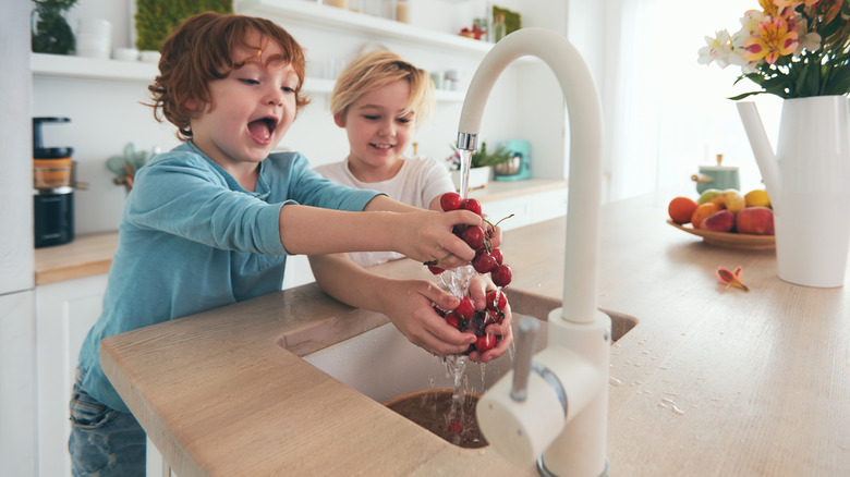 kids washing cherries in sink