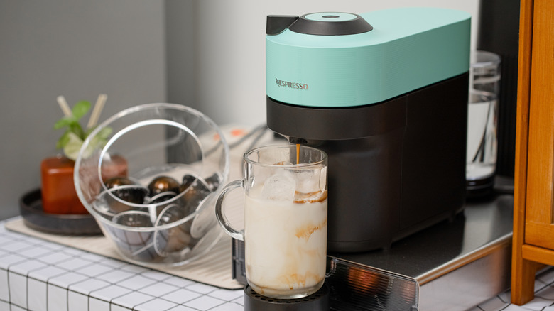 Teal Nespresso machine pouring a drink