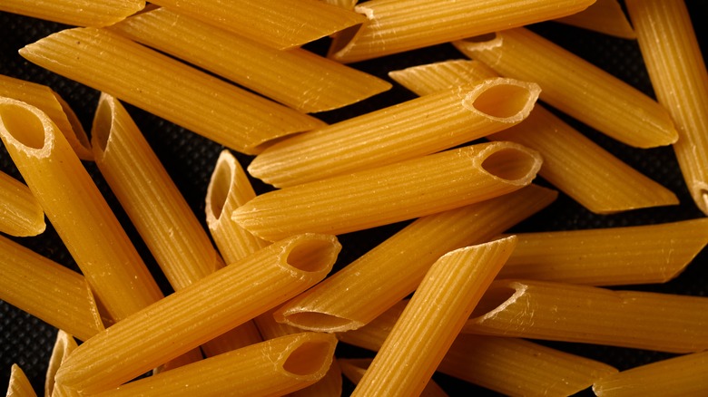 Dry penne on black background