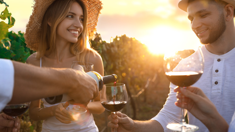 woman watches man tasting wine