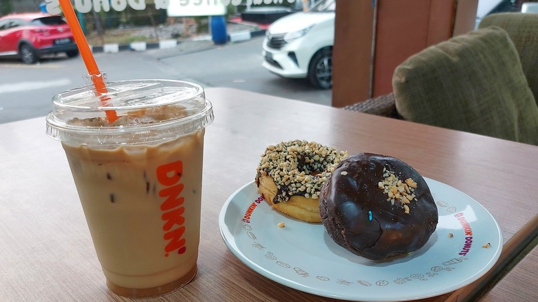 Dunkin' iced coffee on table with donuts