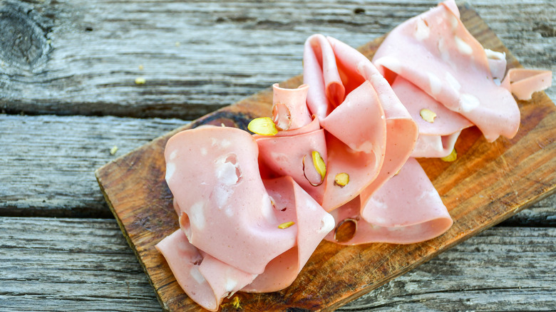 Sliced mortadella on wooden board