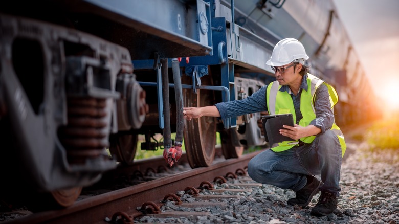 A railroad worker inspecting a train