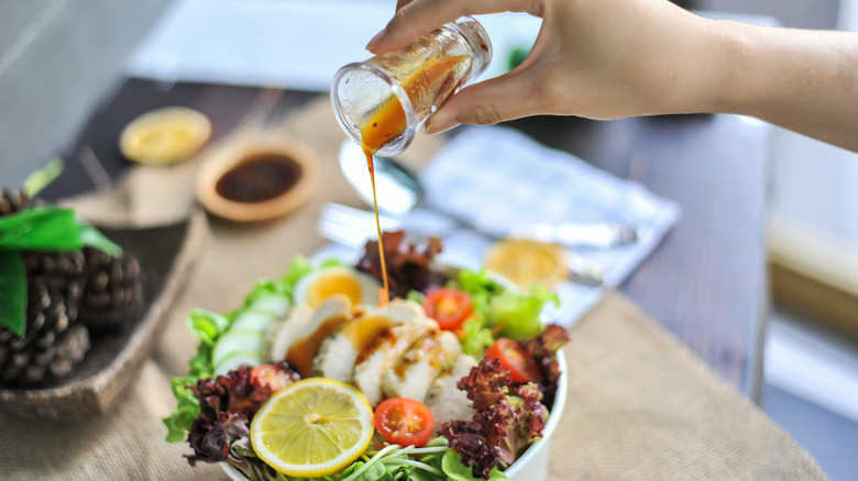 pouring french dressing over salad