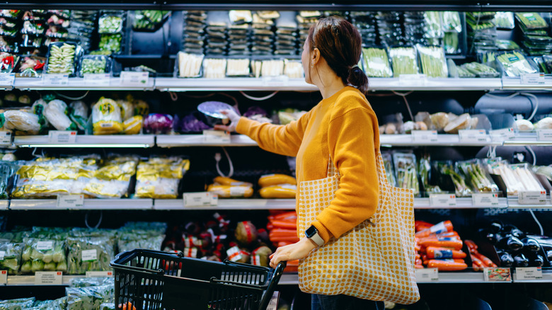 Woman examining food packaging at grocery store