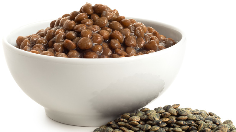 Bowl of cooked lentils next to dry ones