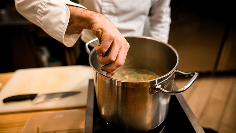 cook stirring stock pot