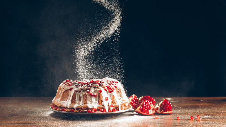 Sugar being sprinkled on dessert.