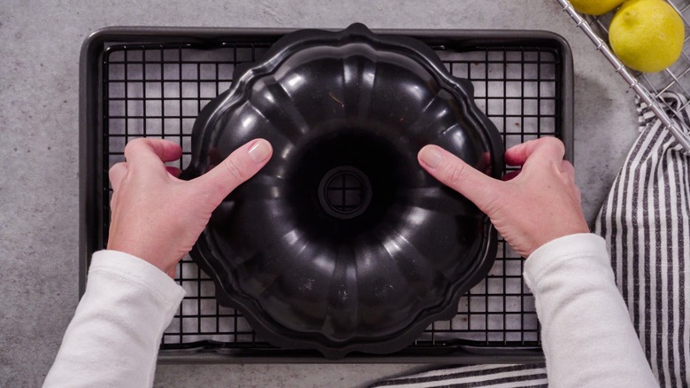 someone holding bundt cake pan