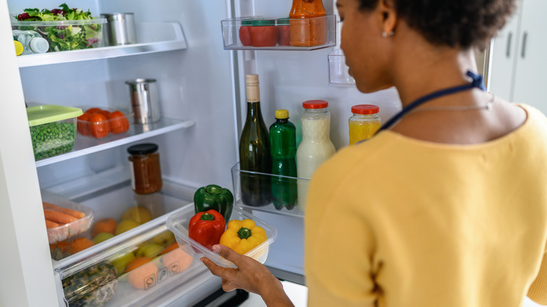 Woman looking inside fridge