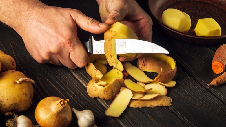 Peeling potatoes with knife 