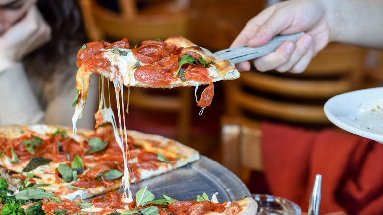 server giving slices of pizza