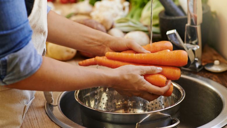 Home cook washing carrots 