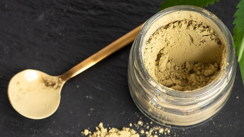 Green-tinged powder in a jar with spoon